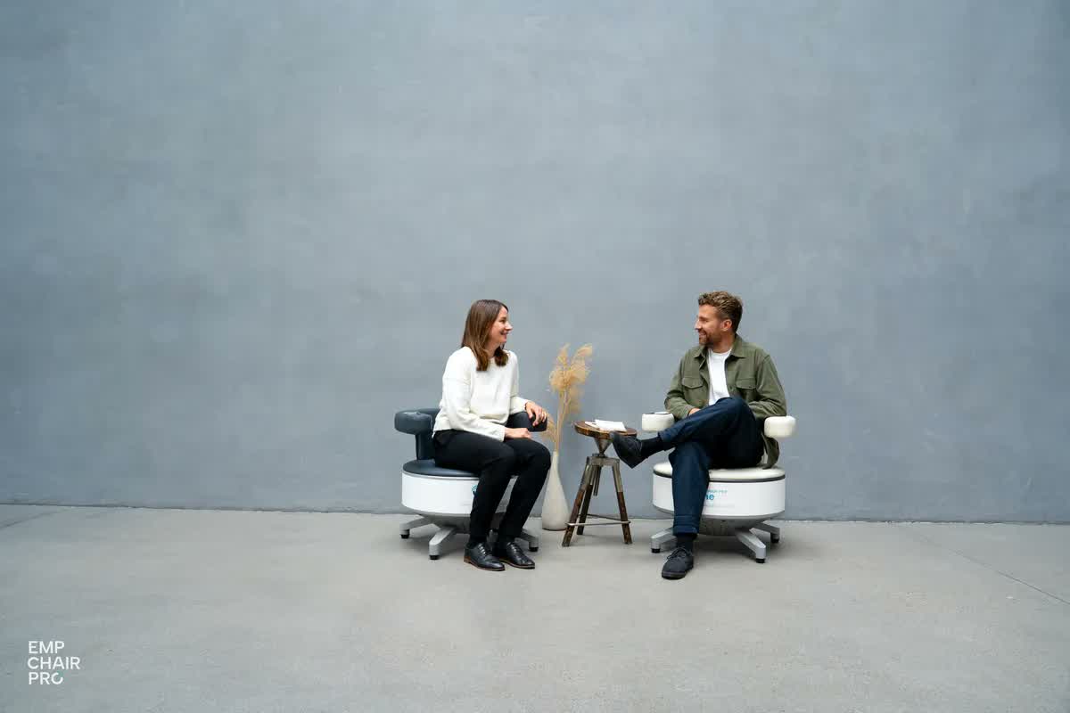 Eine Frau und ein Mann sitzen sich auf zwei EMP Chair Pro gegenüber und unterhalten sich